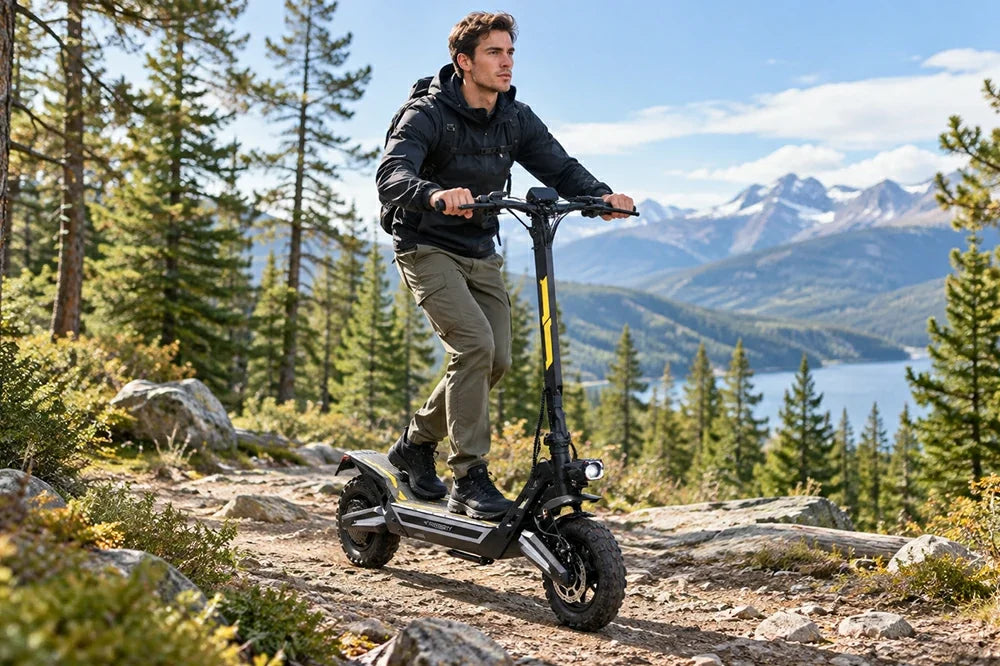 Man riding Freeboy J2 Max electric scooter on rocky forest mountain trail